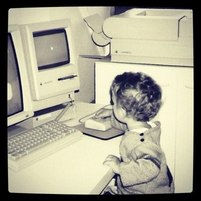 A childhood photo of Valentin at an early Apple computer, with his hand on the mouse